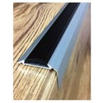 A black and silver stair rail with a rubber insert on a wooden floor.