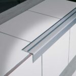 A close up of a white sink with a metal edge featuring a Warrior Stair Nosing 45MM Height 25MM Width ASN4525AL.