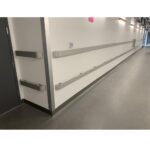 A hallway in a hospital with metal railings protected by the Warrior SS 316 Wall Guard.