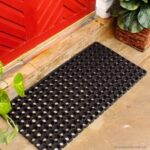 A black Warrior Rubber Hollow Mat 22MM Thk 100CM Width 150CM Length in front of a red door.
